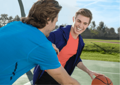 Men playing basketball smiling