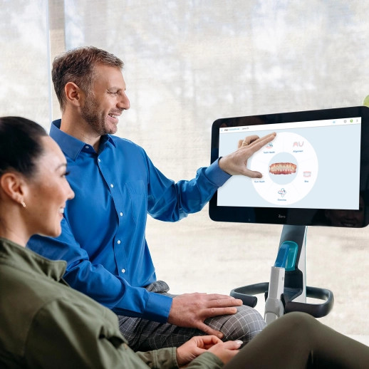 Male doctor showing image on iTero to female patient