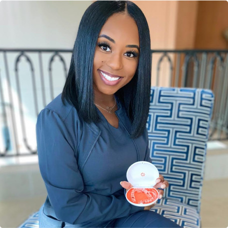 Black young woman showing her Vivera retainers on a case