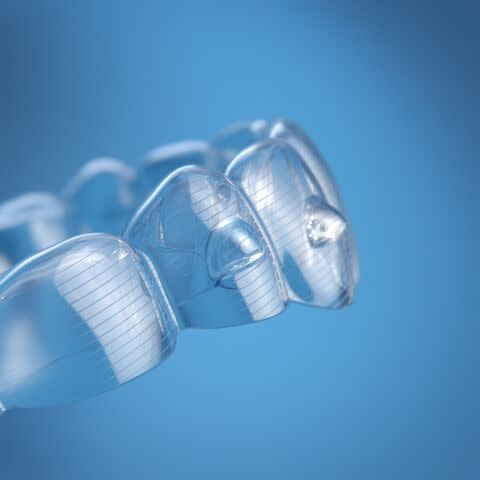 Lekarka pokazuje pacjentowi jego nakładki Invisalign®