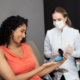 Female doctor showing her patient his Invisalign® aligners