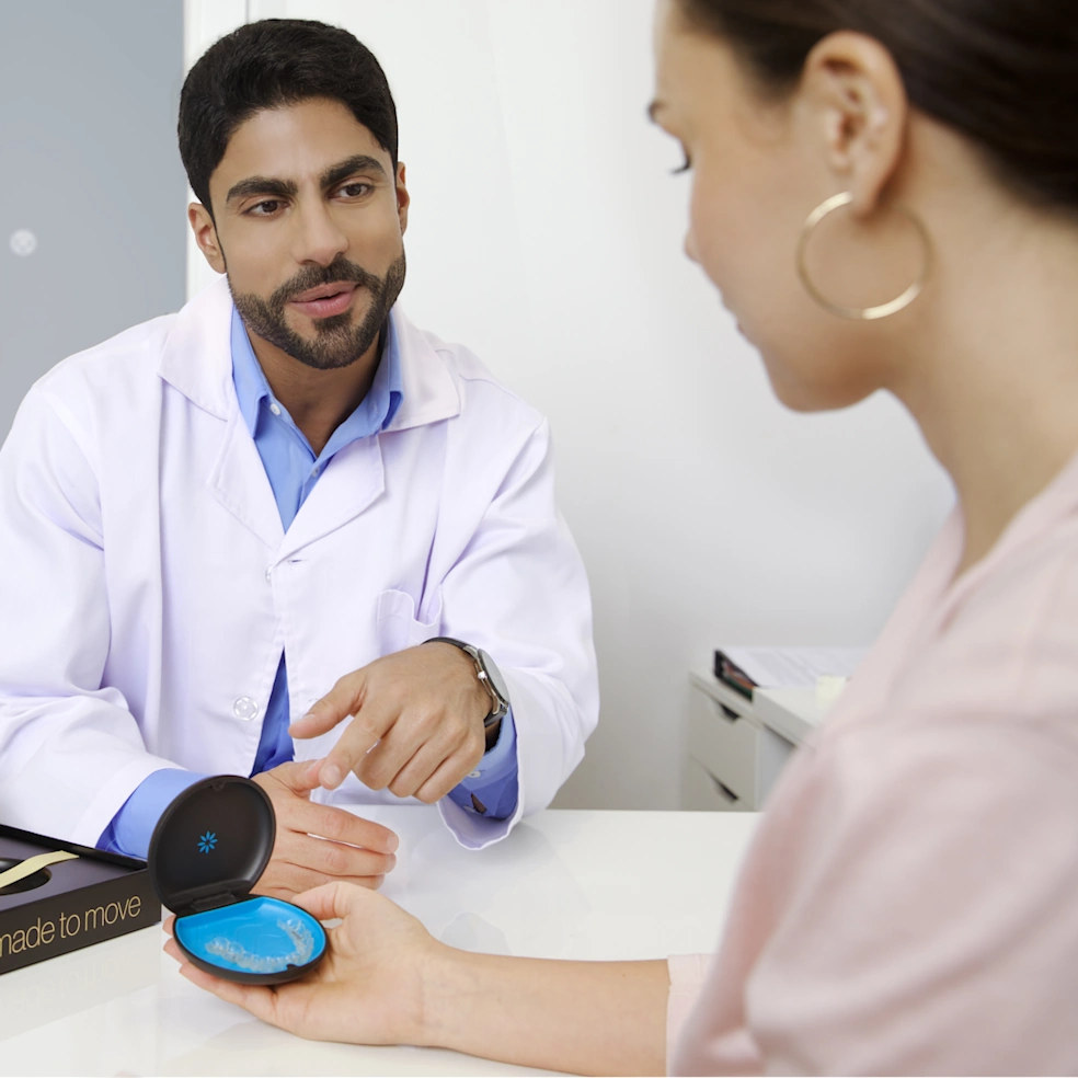 طبيب يوضح لمريضة كيفية استخدام تقويم Invisalign® الشفاف أثناء الاستشارة
