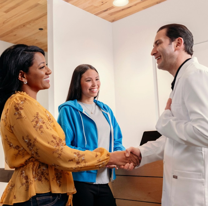 Girl teen and mom shaking hands with their Invisalign doctor