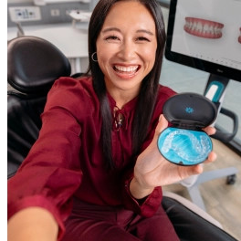 Young woman smiling and showing to the camera her aligners in their case