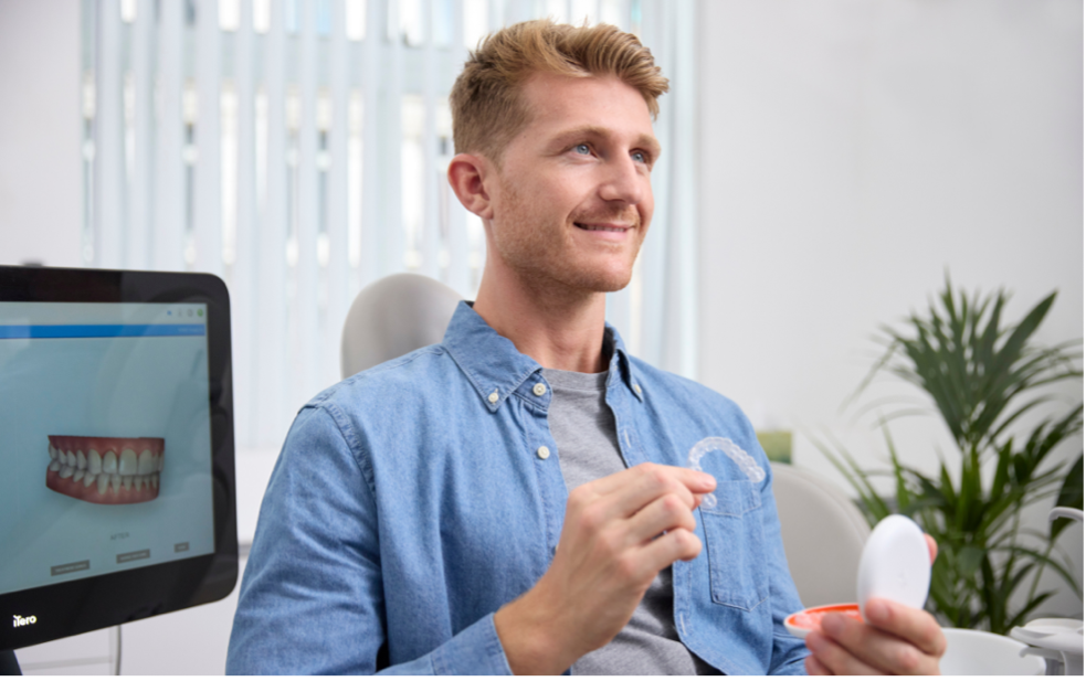 Red hair man holding aligners