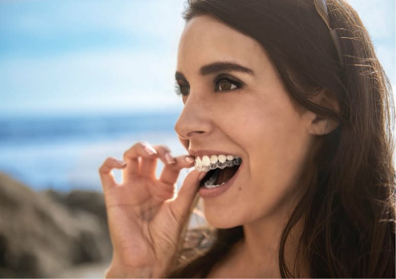 Donna che sta per indossare il suo allineatore trasparente - Invisalign Italia