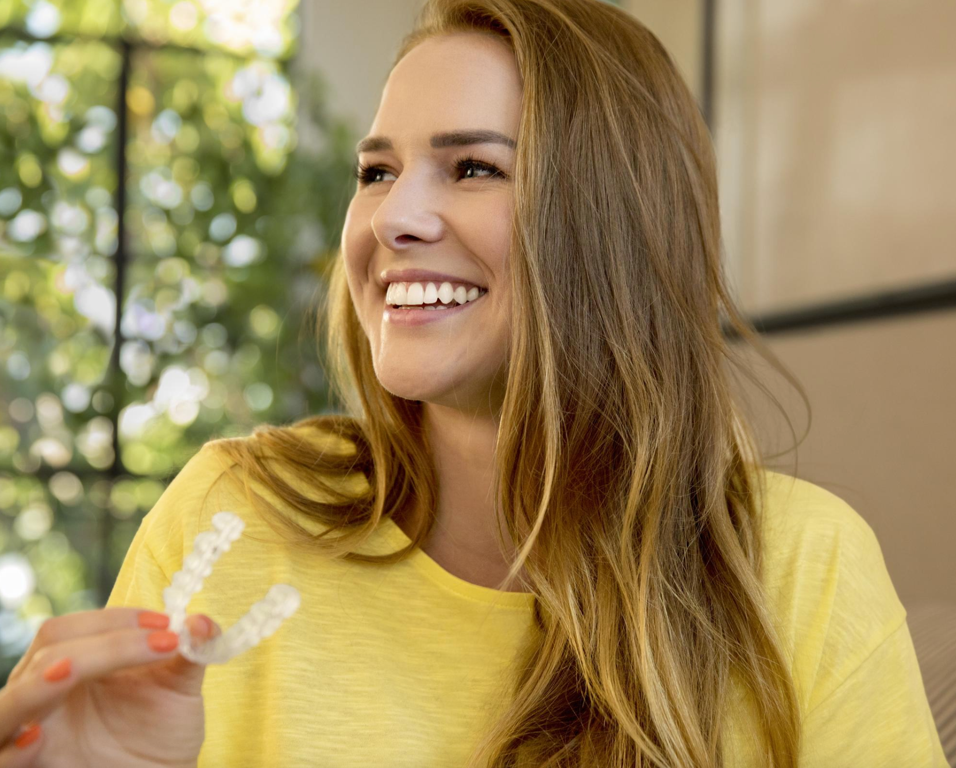 Young brunette woman putting in her retainers