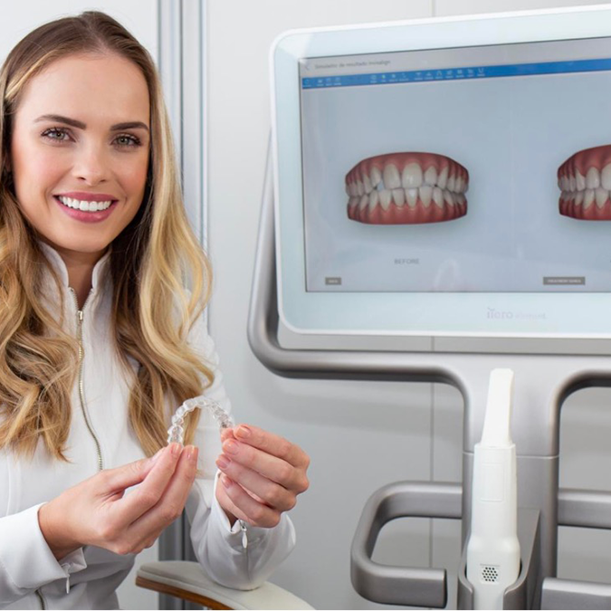 Lekarz Invisalign® pokazuje na ekranie nakładki Invisalign® oraz przebieg leczenia