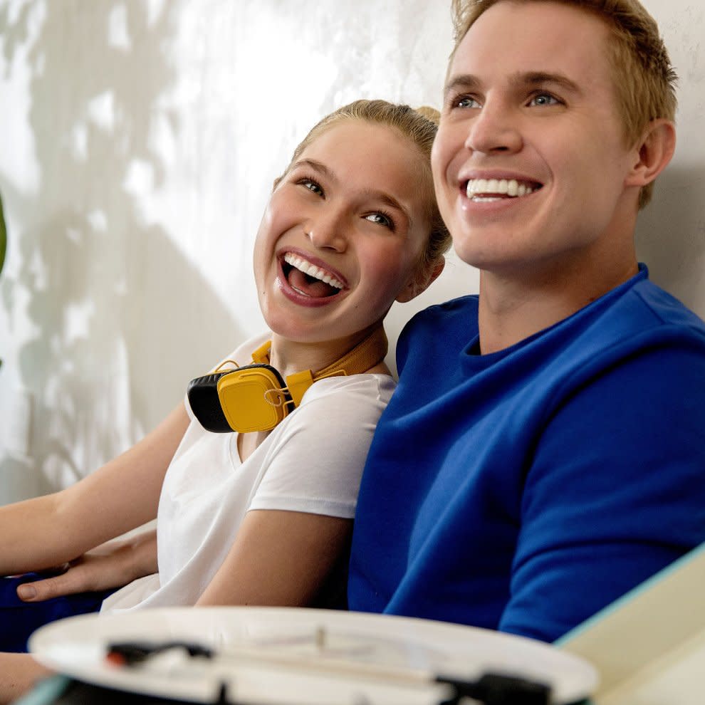 Bir çift, balonlu bir partide Invisalign® sonuçlarından mutlu bir şekilde gülümsüyor