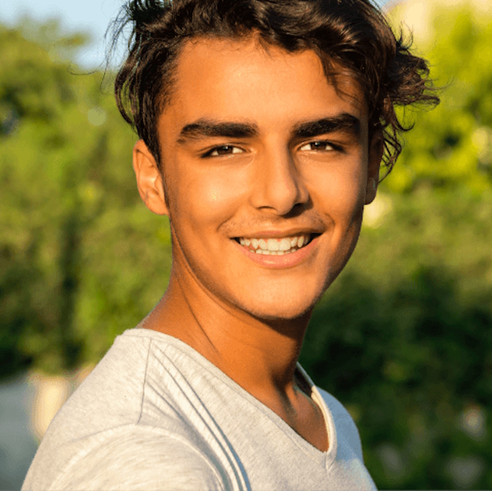 Teen boy smiling after Invisalign® treatment