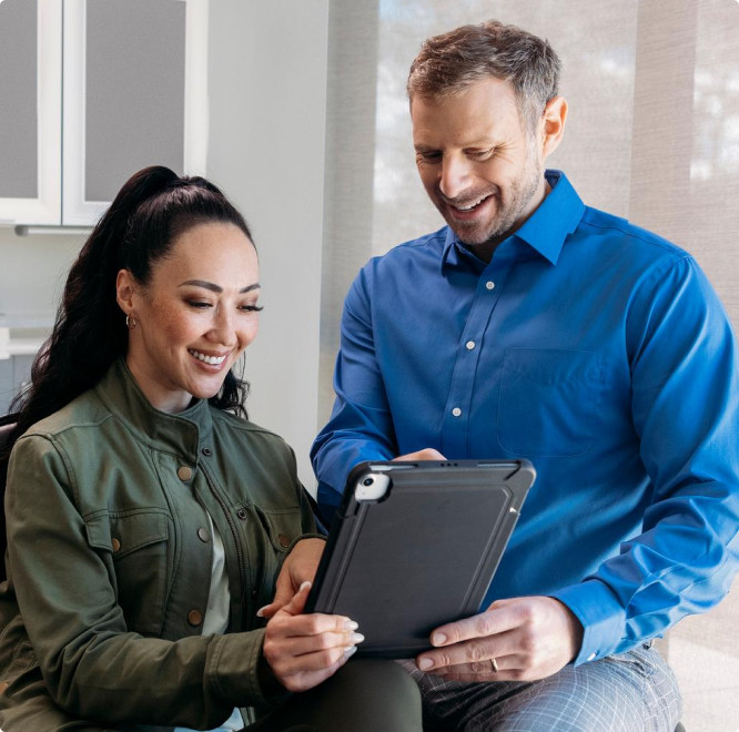 Invisalign doctor and his female patient checking tablet