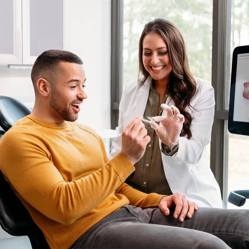 Invisalign® doctor showing her patient his new clear aligners