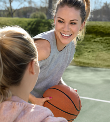 Girls playing basketball while wearing clear aligners