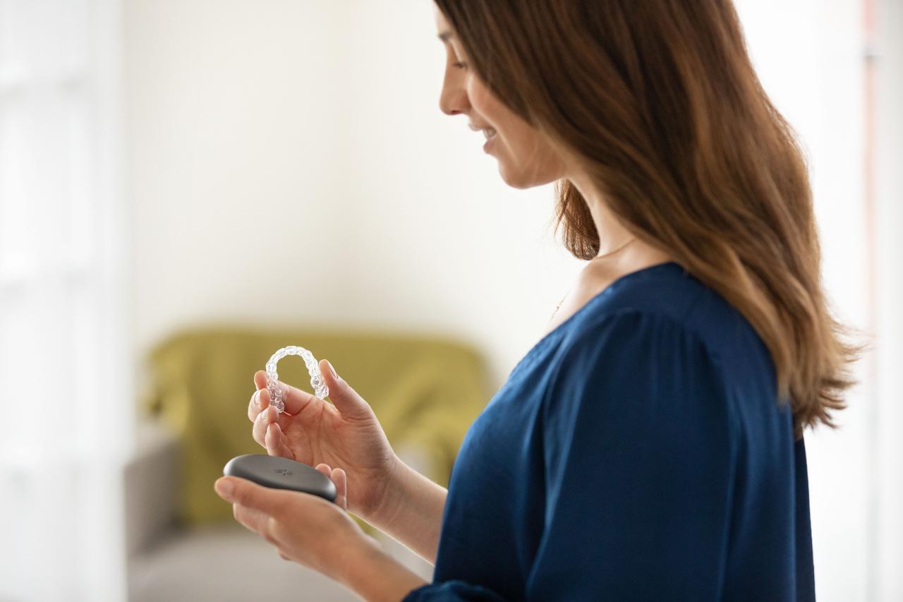 Woman holding her aligners and their case