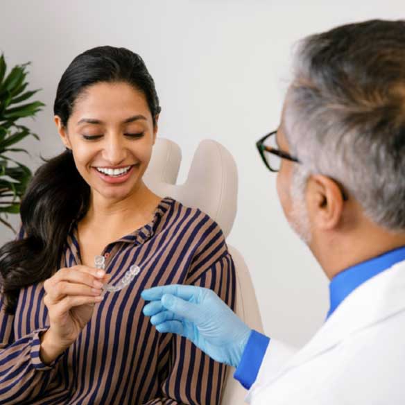 Dentiste remettant au patient des appareils de rétention Vivera