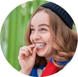 Young woman smiling while putting on Vivera™ Retainers