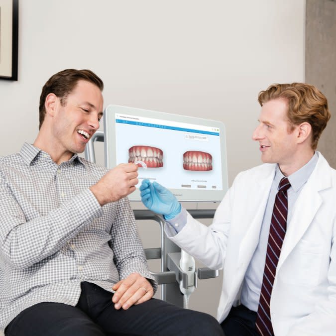 Genç bir kadın, şeffaf plaklarını erkek doktordan teslim alıyor