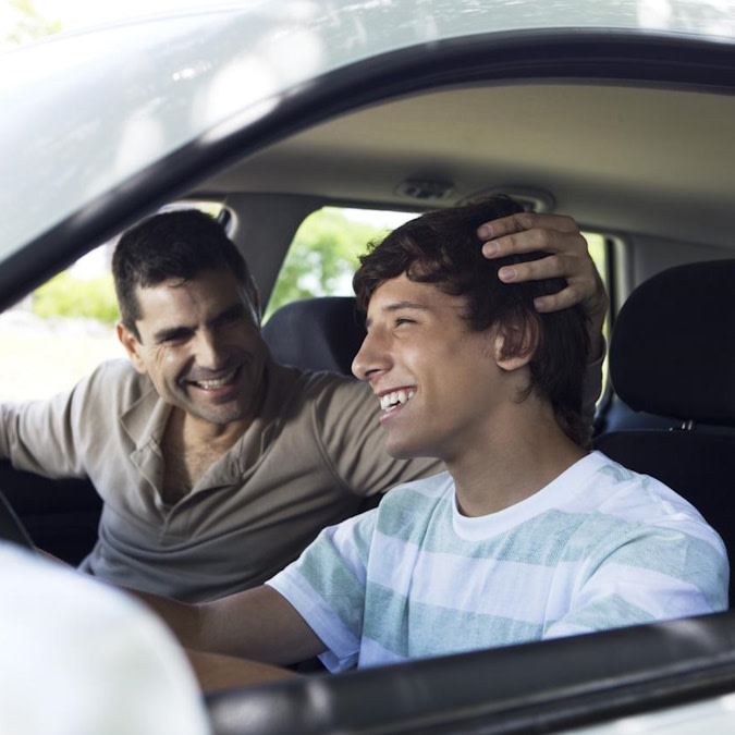 Padre e figlio sorridono in auto dopo il trattamento Invisalign®