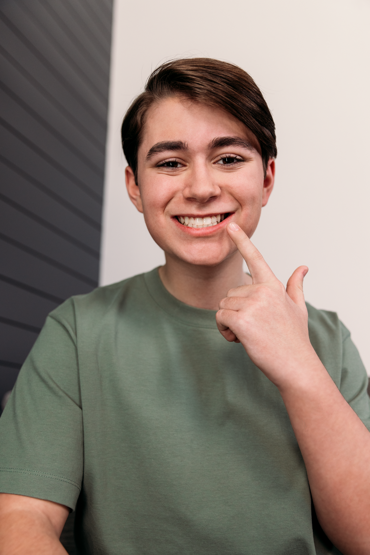 Teen boy showing his straightened teeth through Invisalign Clear Aligners