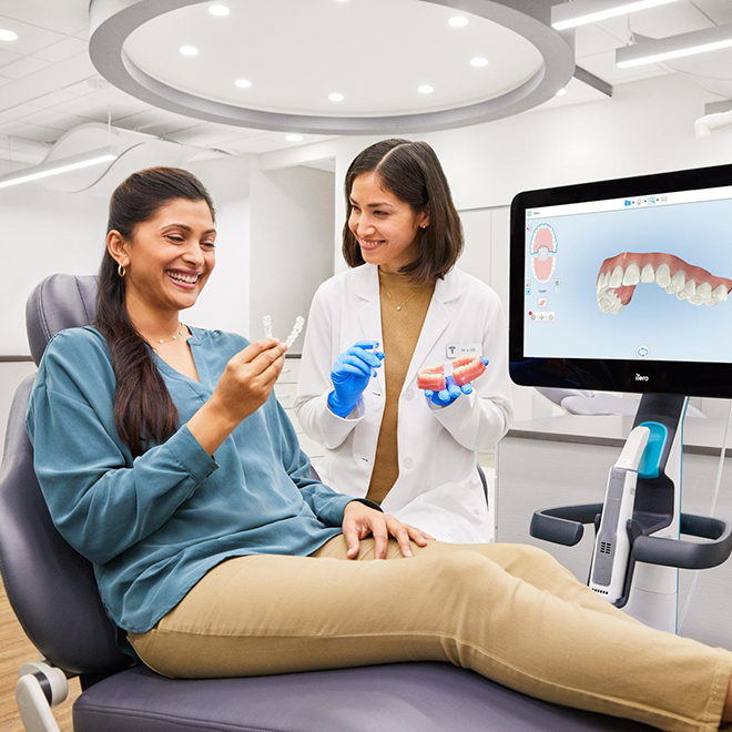 Invisalign® male doctor showing aligners to his male patient with iTero scanner