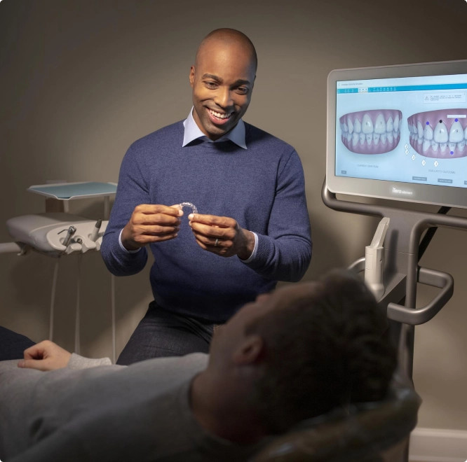 Invisalign® male doctor showing aligners to his male patient with iTero scanner