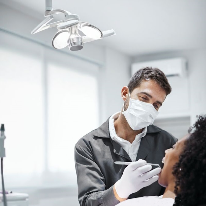Doctor examines a patient’s teeth during Invisalign® consultation