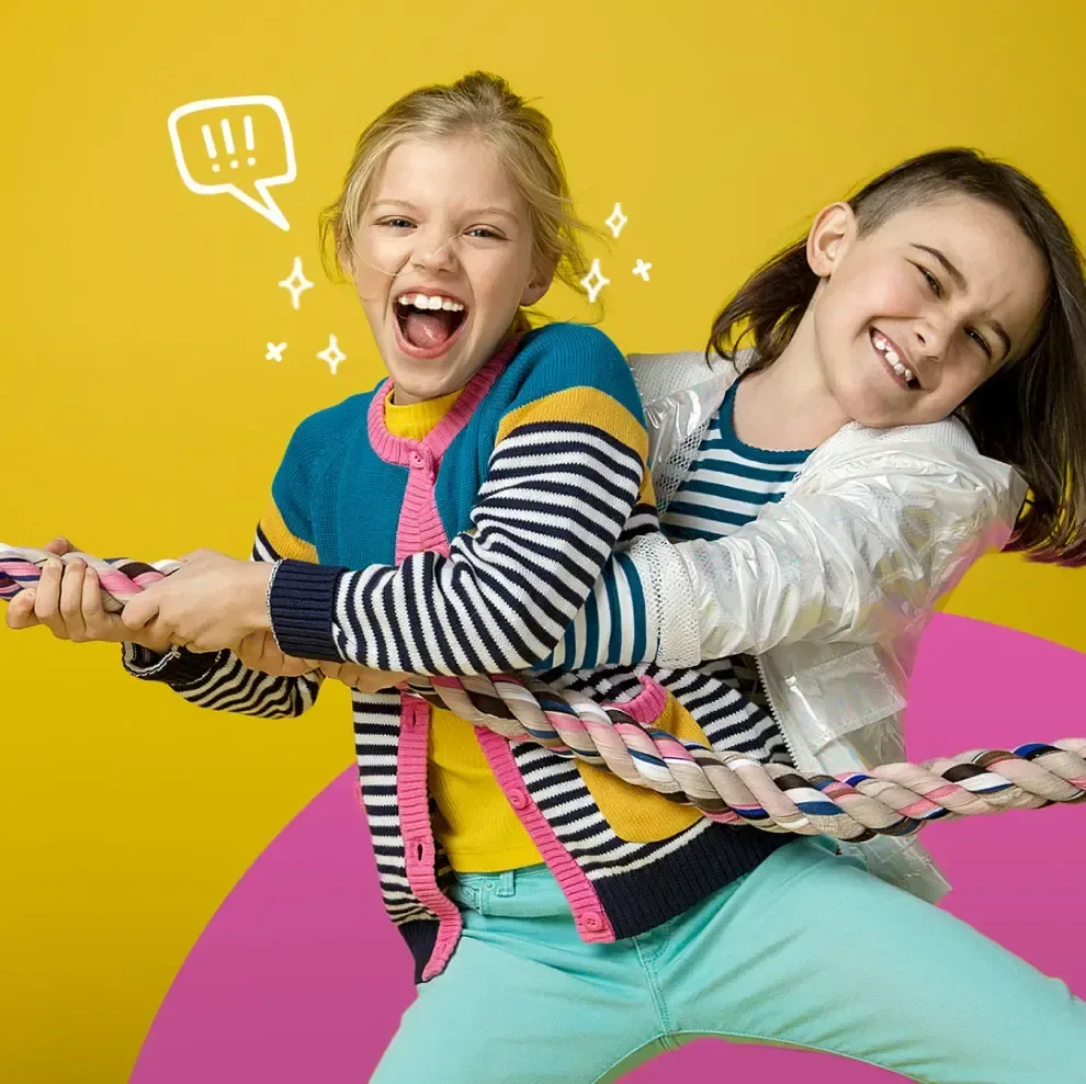 Ragazze che giocano al tiro alla fune e sorridono