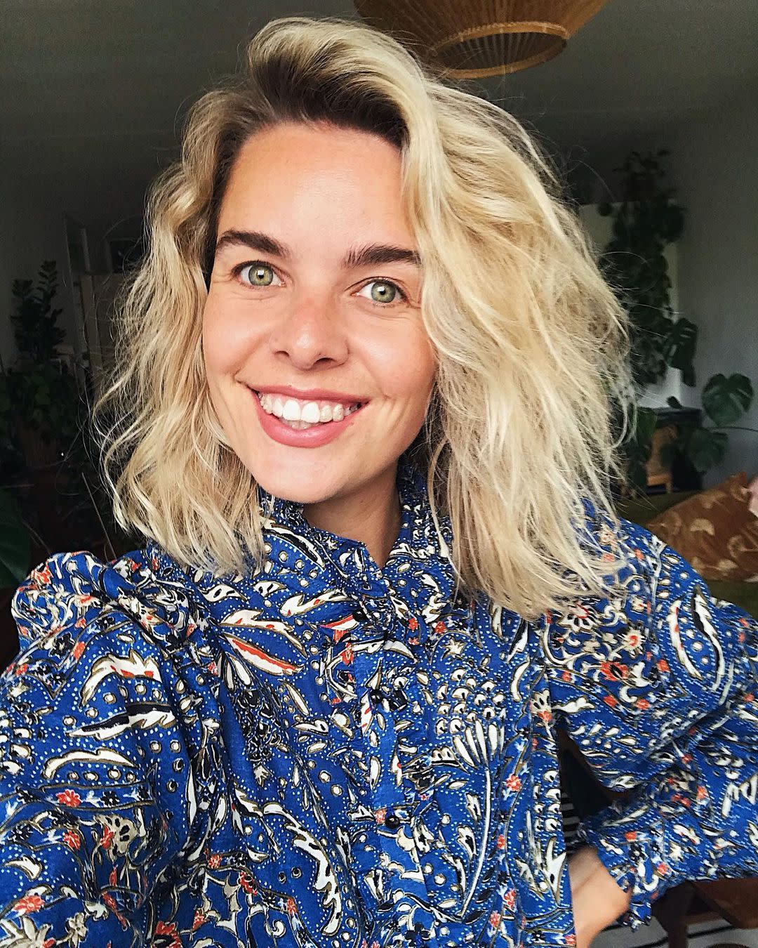 Woman smiling to the camera while wearing her clear aligners