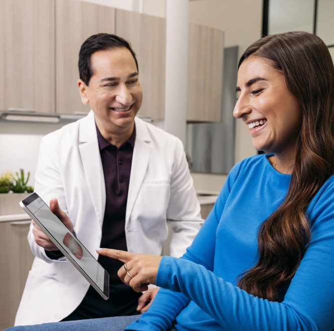 Invisalign® male doctor showing Align Digital Platform™ to his female patient