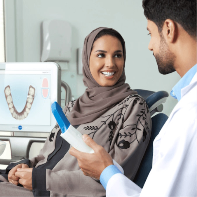 طبيب يشرح علاج Invisalign® لمريضة خلال الاستشارة