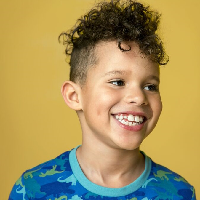 Smiling child showing healthy teeth after Invisalign® First treatment