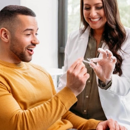 Invisalign® female doctor giving her male patient his new aligners