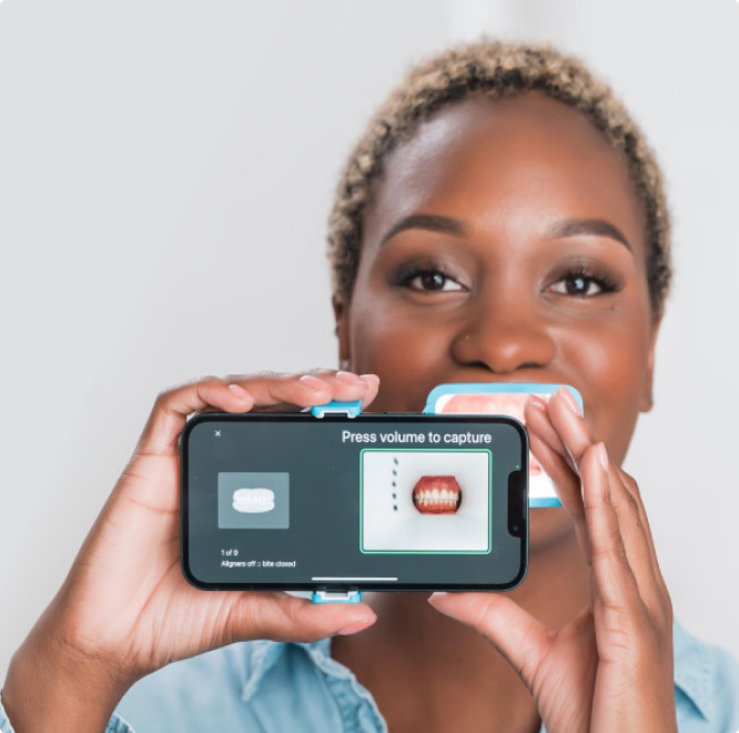 Black woman taking a picture of her tooth using Invisalign Virtual Care AI tool