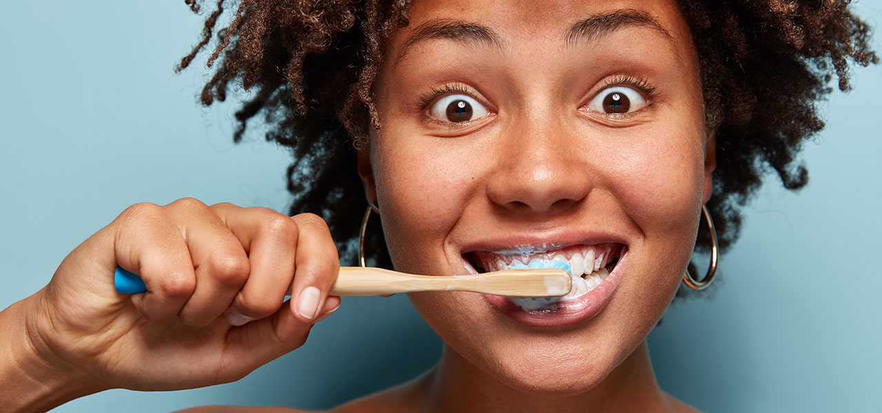 Young woman brushing her smile without brackets