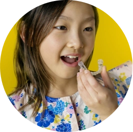 Little girl trying on her new Invisalign® aligners