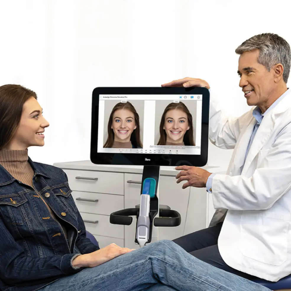 Doctor de Invisalign® enseñando a su paciente el posible antes y el después de su sonrisa con la tecnología ClinCheck