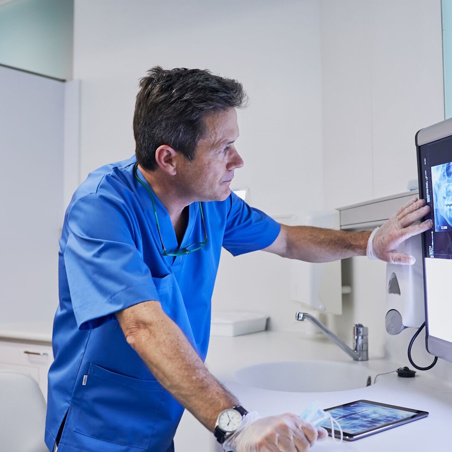 طبيب يحلل مسحًا رقميًا لأسنان على الشاشة أثناء تخطيط علاج Invisalign®
