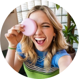 Ragazza adolescente sorridente che mostra la custodia rosa degli allineatori Invisalign®.