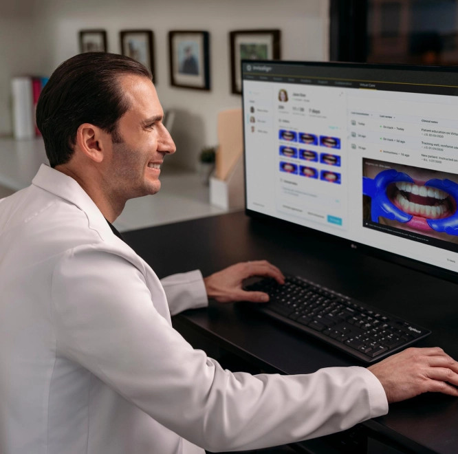 Invisalign® male doctor checking teeth scanner on computer