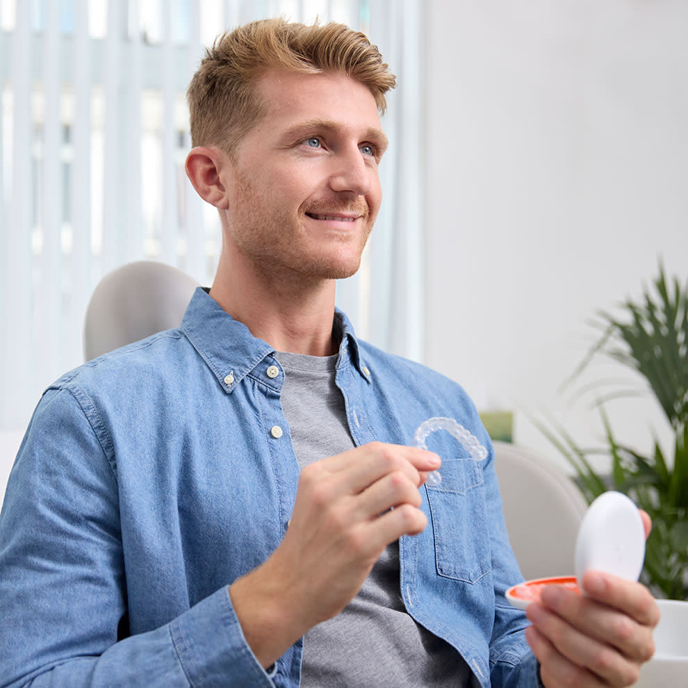 Uomo che estrae i Vivera™ Retainers dalla loro custodia.