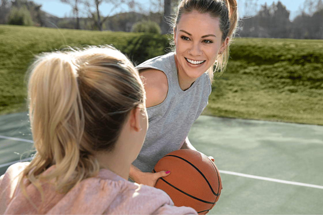 Girls playing basketball while wearing clear aligners