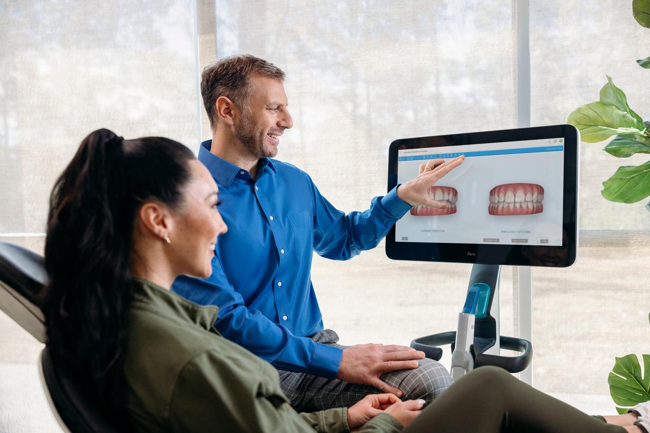 Invisalign doctor with female patient checking iTero scanner