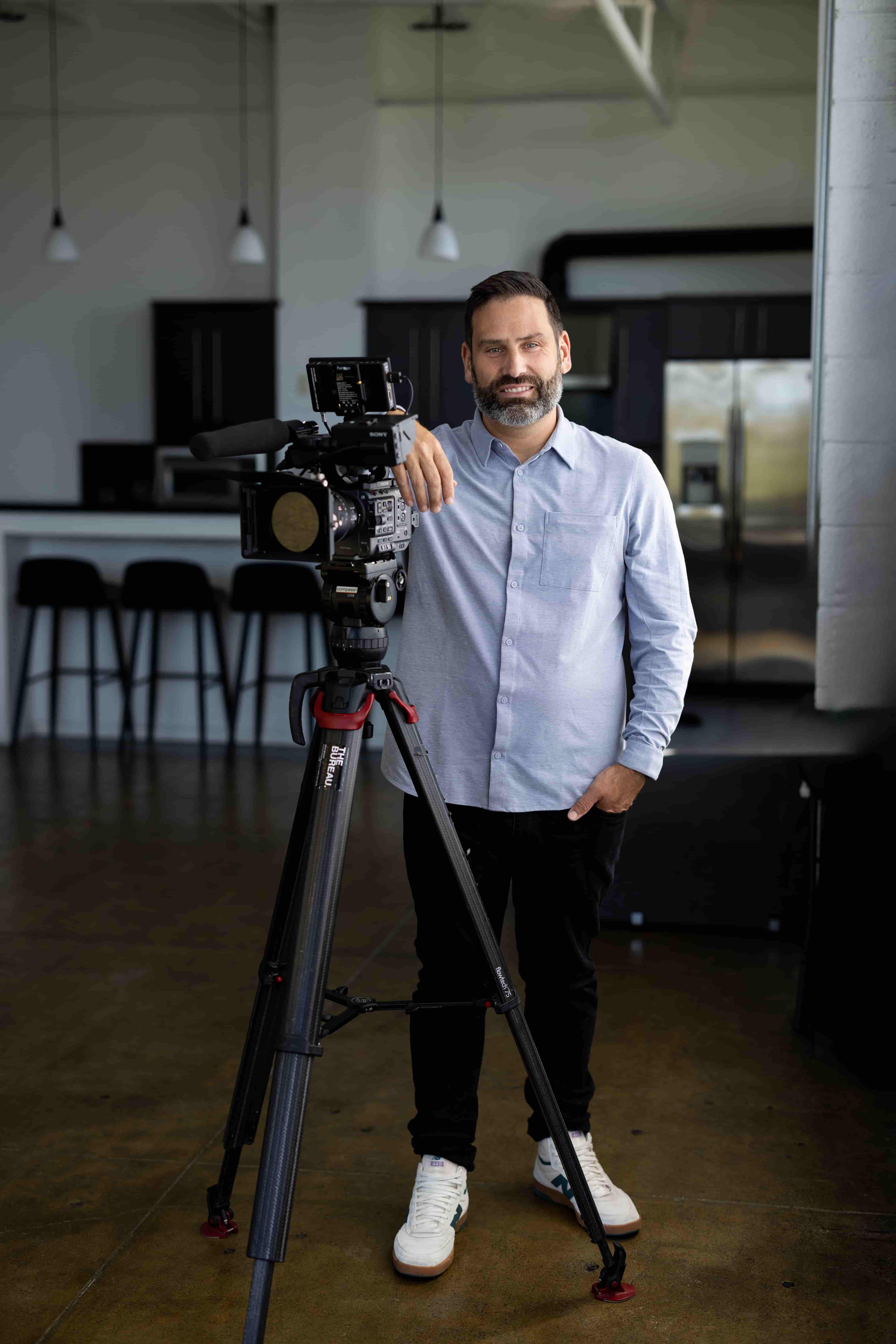 Photo of Kyle Decker standing next to a camera