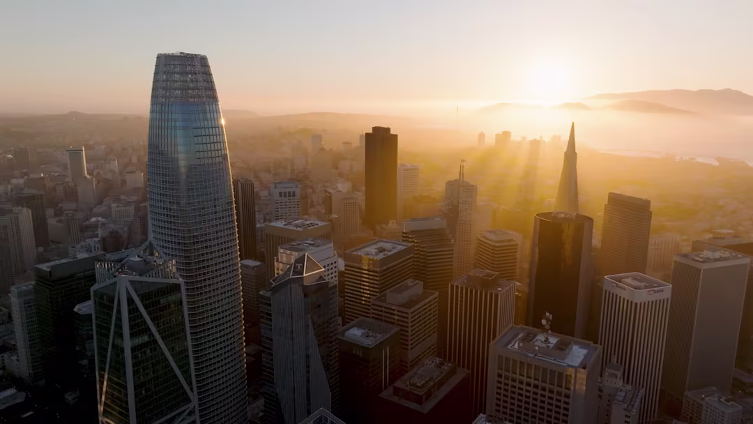Aerial drone shot of the San Francisco skyline at golden hour featuring Salesforce Tower and the Transamerica Pyramid. Shot for Philip Farr's luxury real estate brand video by The Bureau.