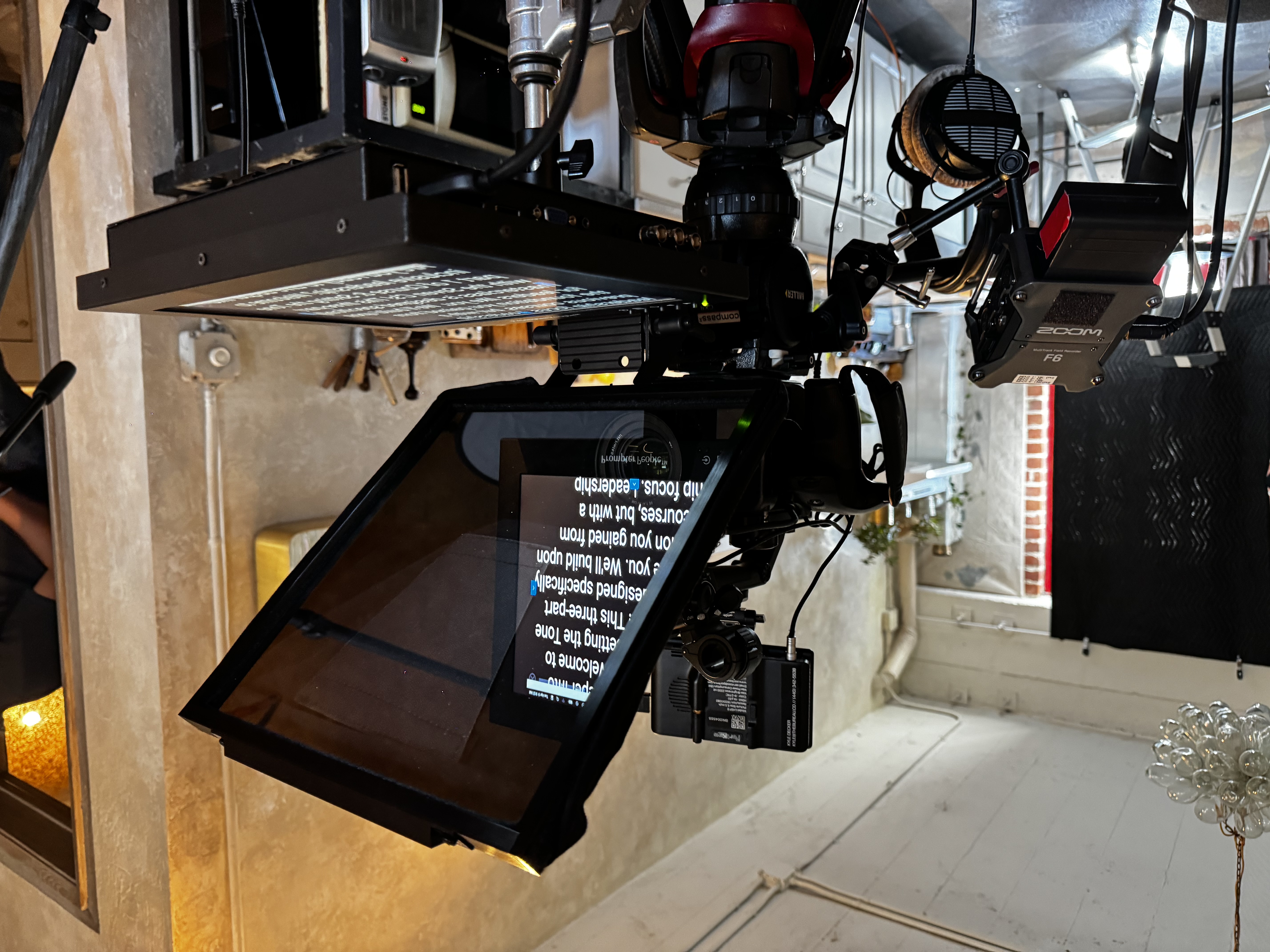 A professional teleprompter and beam-splitter rig mounted on a cinema camera during a corporate video shoot, with a script reflected on the glass — illustrating the modern teleprompter workflow used in executive interviews.