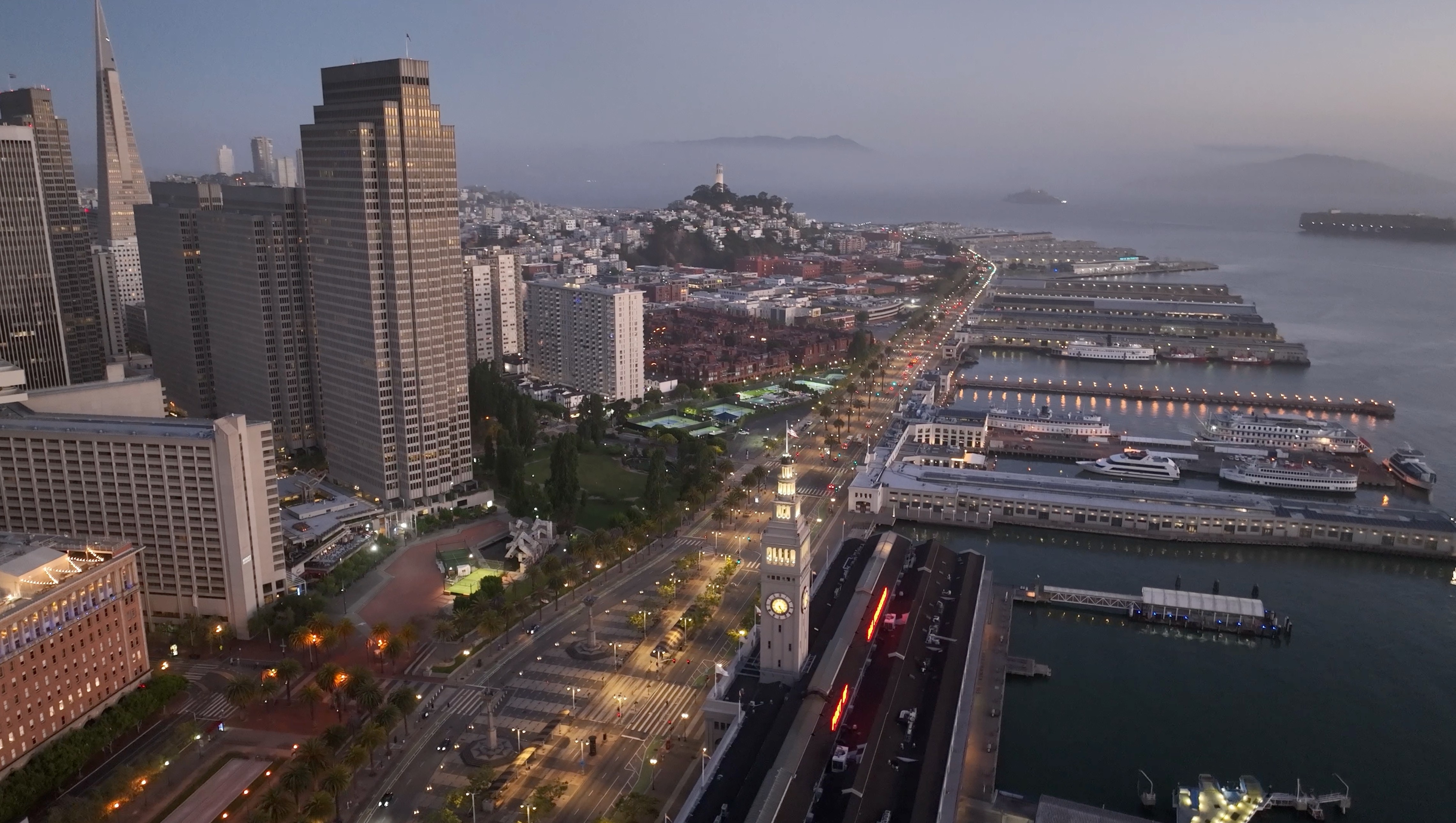 Aerial drone shot of the San Francisco Embarcadero and Ferry Building at dusk, captured for Philip Farr's luxury real estate brand video by The Bureau video production.