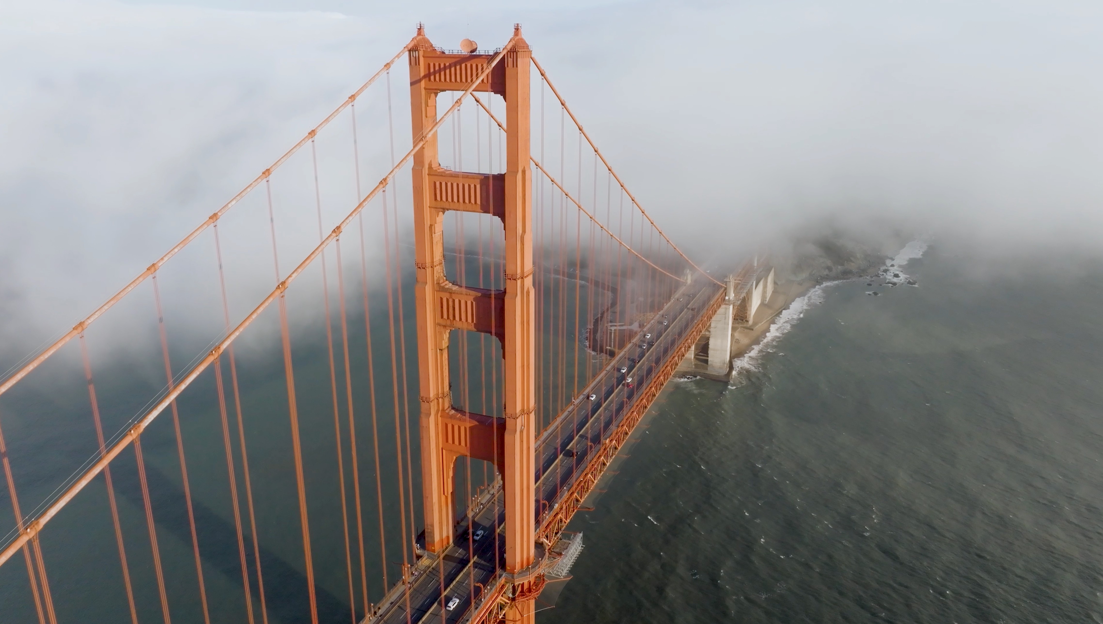 Aerial drone shot of the Golden Gate Bridge shrouded in San Francisco fog. Featured in Philip Farr's luxury real estate brand video produced by The Bureau.