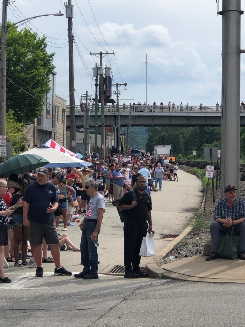Crowds gather and await the train.