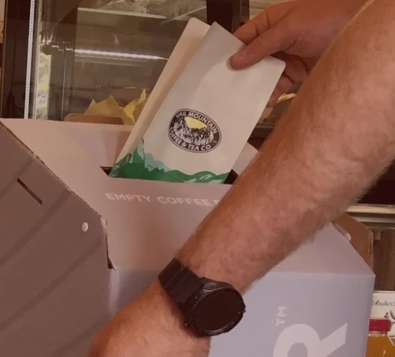 Vail Coffee bag being deposited in the R+R® Box.