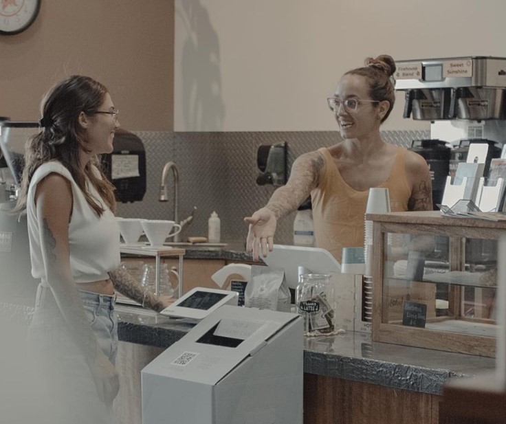 Barista introducing the R+R® Box to a customer.